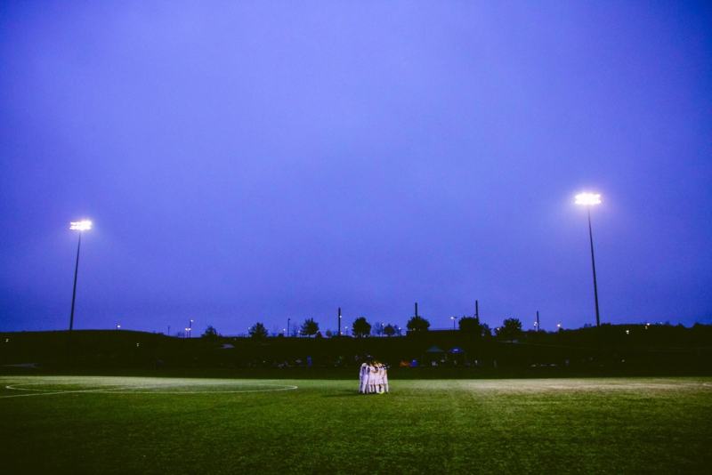 Football pitch under floodlights at dusk