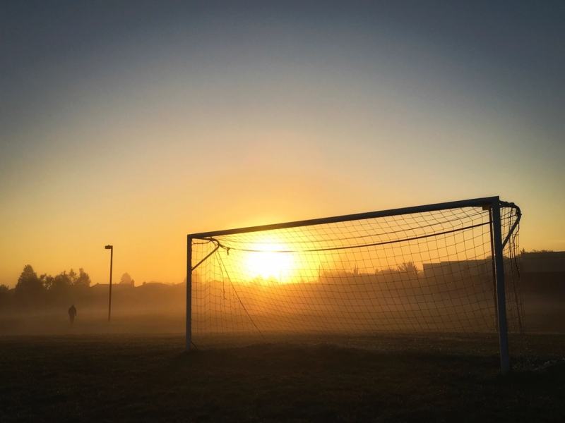 Silhouette of a football goal at sunset