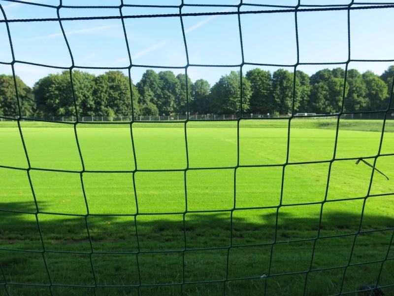 A football pitch seen through the goal net